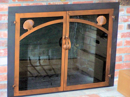 Nauset has scallop shell motif black frame antique copper twin doors, forged handles smoke glass 